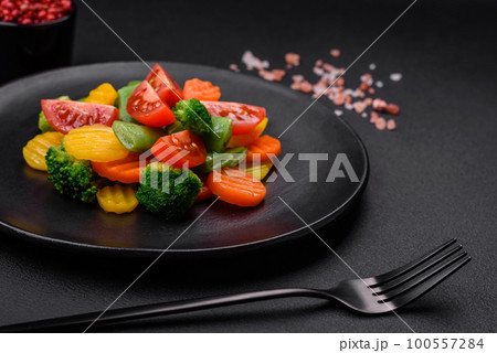 Salad of fresh and steamed vegetables cherry tomatoes, broccoli and carrots 100557284