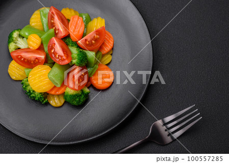 Salad of fresh and steamed vegetables cherry tomatoes, broccoli and carrots 100557285