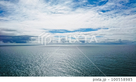 Cape Roca, Sintra, Portugal - June 3, 2018: view of the peaceful Atlantic Ocean with waves and under a cloudy blue sky Cape Roca, Sintra, Portugal - June 3, 2018: view of the peaceful Atlantic Ocean with waves and under a cloudy blue sky 100558985