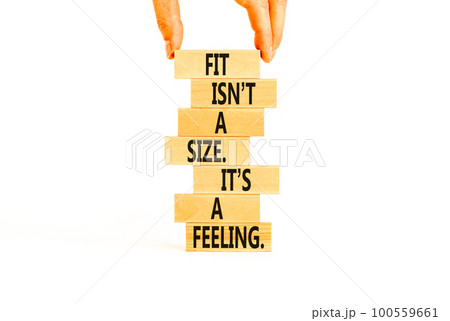 Fit, size or feeling symbol. Concept words Fit is not a size it is a feeling on wooden blocks. Beautiful white background. Copy space. Businessman hand. Motivational fit size or feeling concept. 100559661