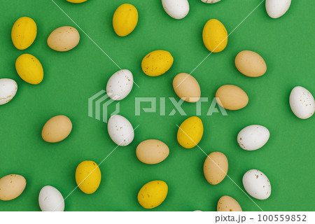 Chocolate Easter eggs on green background 100559852