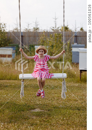 The child sways on a swing. 100561816