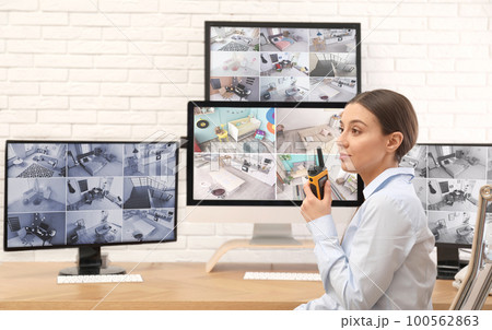 Female security guard with portable transmitter at workplace Female security guard with portable transmitter at workplace 100562863