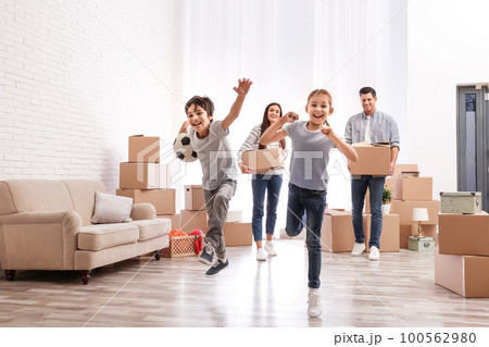 Happy family in room with cardboard boxes on moving day Happy family in room with cardboard boxes on moving day 100562980