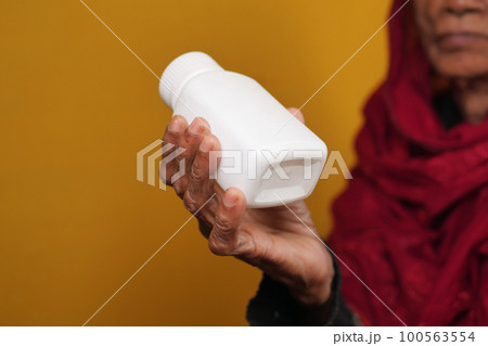 senior women holding a medical pill container senior women holding a medical pill container 100563554