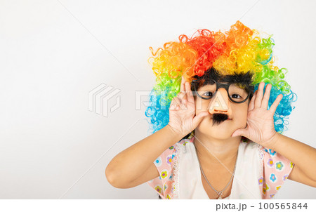 April Fool's Day. Two brothers funny kid little girl clown wears curly wig colorful big nos and glasses and mustache playing fool isolated on white background copy space, Happy child festive decor April Fool's Day. Two brothers funny kid little girl clown wears curly wig colorful big nos and glasses and mustache playing fool isolated on white background copy space, Happy child festive decor 100565844