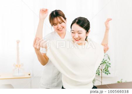 肩周りのストレッチをする整体師の女性と患者（ストレートネック・首こり・鞭打ち） 100566038