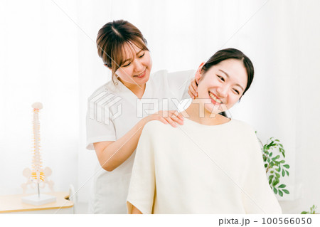 首・頭のマッサージをする整体師の女性と患者（ストレートネック・首こり・鞭打ち） 100566050