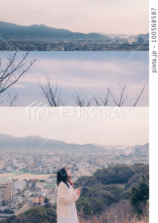 朝日を浴び街をバックに音楽を聴く女性の写真 朝日を浴び街をバックに音楽を聴く女性の写真 100568587