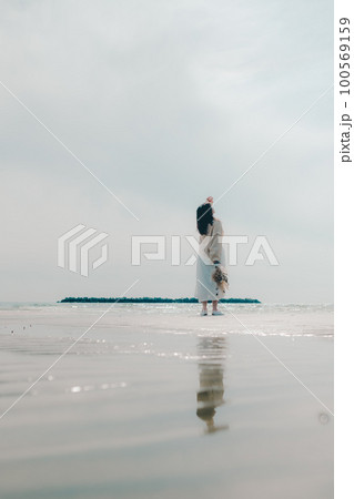 海辺にドライフラワーを持って佇む女性の写真 100569159