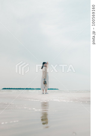 海辺にドライフラワーを持って佇む女性の写真 100569160