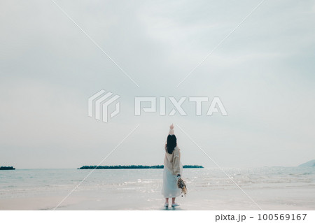 海辺にドライフラワーを持って佇む女性の写真 100569167