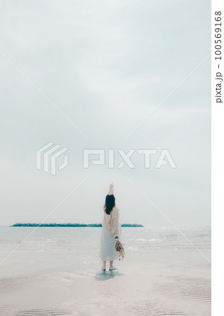 海辺にドライフラワーを持って佇む女性の写真 100569168