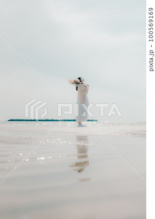 海辺にドライフラワーを持って佇む女性の写真 100569169