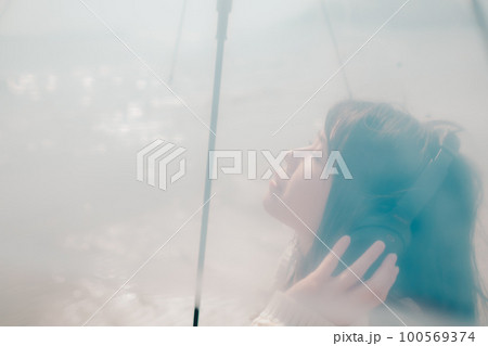 海辺で音楽を聴く女性の写真 100569374