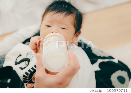 生後まもない赤ちゃんがミルクを飲む写真 100570711