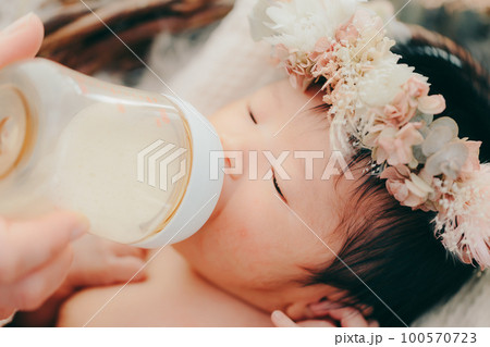 生後まもない赤ちゃんがミルクを飲む写真 生後まもない赤ちゃんがミルクを飲む写真 100570723