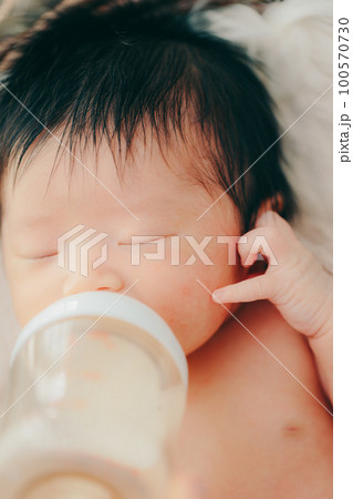 生後まもない赤ちゃんがミルクを飲む写真 生後まもない赤ちゃんがミルクを飲む写真 100570730