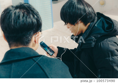 男子大学生が公園でイヤホンで音楽を聴いてる写真 男子大学生が公園でイヤホンで音楽を聴いてる写真 100573490
