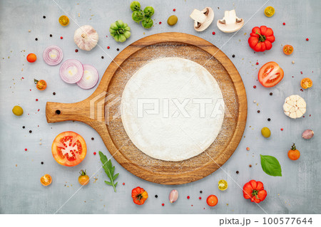 The ingredients for homemade pizza with wooden pizza tray set up on grey concrete background. top view The ingredients for homemade pizza with wooden pizza tray set up on grey concrete background. top view 100577644