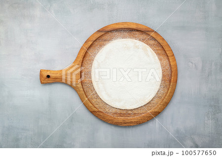 Empty wooden pizza platter set up on grey concrete. Pizza tray on grey concrete background flat lay and copy space. 100577650