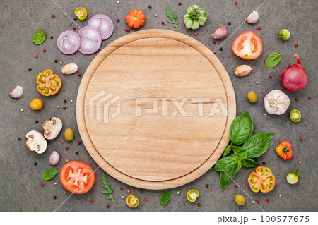 The ingredients for homemade pizza set up on dark stone background. 100577675