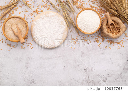 The ingredients for homemade pizza dough with wheat ears ,wheat flour and wheat grains set up on white concrete background. 100577684