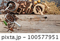 Background of various coffee , dark roasted coffee beans , ground and capsules with scoops setup on wooden background with copy space. 100577951