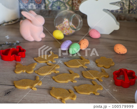 Womens hands close-up kneading ginger dough and carving figurines 100579999