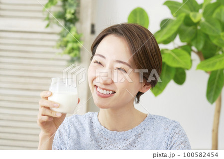 家で牛乳を飲む女性 100582454