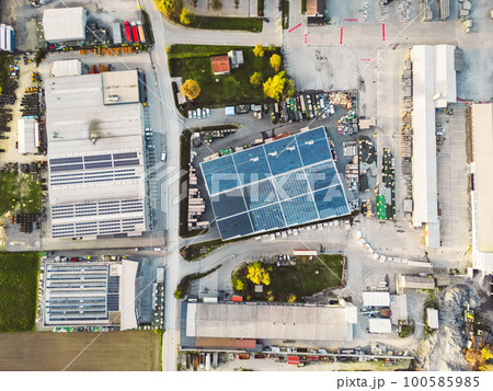 Birdseye view of industrial area with a large warehouses, solar panels on the roof tops Birdseye view of industrial area with a large warehouses, solar panels on the roof tops 100585985