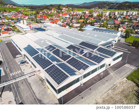 Drone view warehouse in the suburbs with roof top covered in solar panels 100586037
