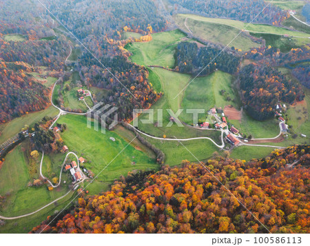 Drone flying over green hills and valleys in the rural area outside the city 100586113