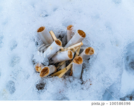 Snow ashtray with cigarette butts and matches. Snow ashtray with cigarette butts and matches. 100586396