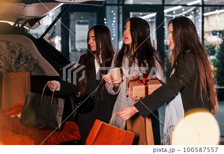 After shopping. Three cheerful women spends Christmas holidays together outdoors. Conception of new year 100587557