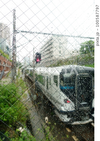 雨に濡れたガラス越しに電車の通過を見る 100587797