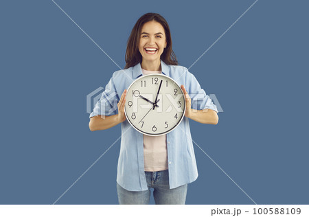 Happy excited young woman holding big wall clock 100588109