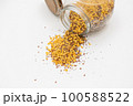 Yellow lentils and flaxseed mixed pour from the bottle 100588522