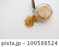 Yellow lentils and flaxseed mixed pour from the bottle 100588524