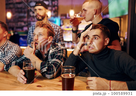 Group of people together indoors in the pub have fun at weekend time Group of people together indoors in the pub have fun at weekend time 100589931