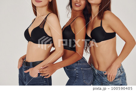 Sexy bodies. Three young women in lingerie together indoors. White background 100590405