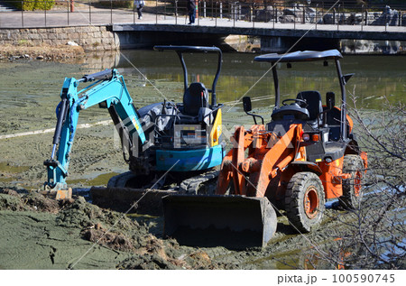 水が抜かれた池に降ろされた重機 100590745