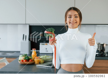 Young european woman is indoors at kitchen indoors with healthy food Young european woman is indoors at kitchen indoors with healthy food 100592061