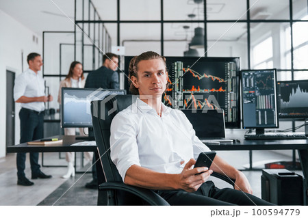 Ordinary office day. Team of stockbrokers works in indoors with many display screens Ordinary office day. Team of stockbrokers works in indoors with many display screens 100594779