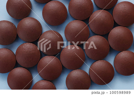 Brown pills on a blue background top view. Brown pills on a blue background top view. 100598989