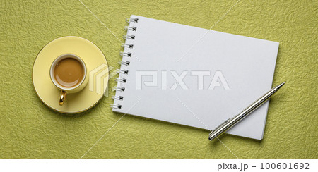 blank spiral sketchbook against textured paper with a cup of coffee, desktop flat lay blank spiral sketchbook against textured paper with a cup of coffee, desktop flat lay 100601692