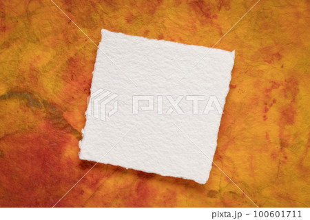 small square sheet of blank white Khadi paper against colorful marbled paper small square sheet of blank white Khadi paper against colorful marbled paper 100601711
