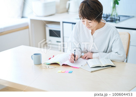 テキストで勉強する女性 100604453