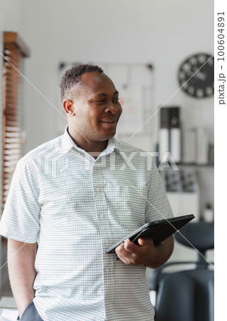 Smiling confident African American businessman at office. Strategy, chart, finance report concept Smiling confident African American businessman at office. Strategy, chart, finance report concept 100604891