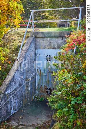 Old entrance to large industrial military bunker with metal door and cement walls Old entrance to large industrial military bunker with metal door and cement walls 100606528
